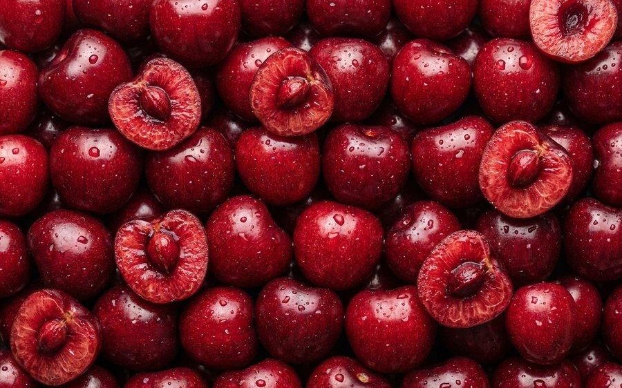 Fresh cherries, some halved, packed edge to edge